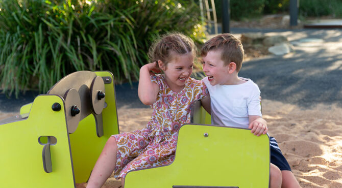 a brother and sister smiling at the edenbrook estate playground in rockhampton