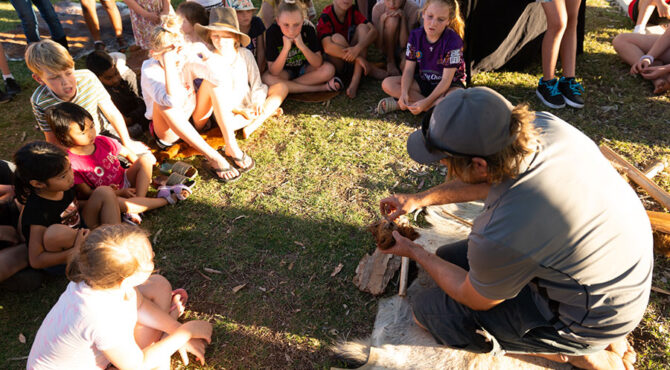 man demonstrating how to build a fire at community event in parkhurst