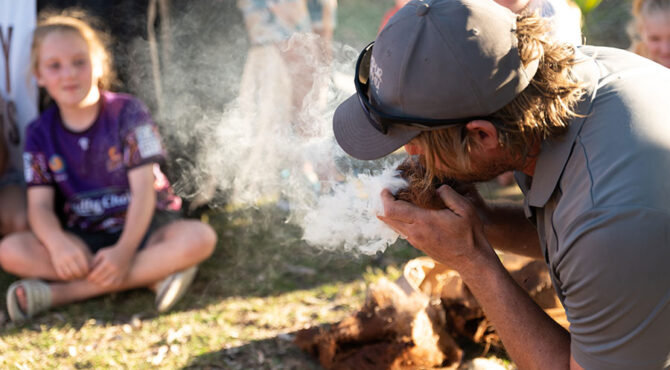 man blowing smoke from fire at edenbrook estate rockhampton community event