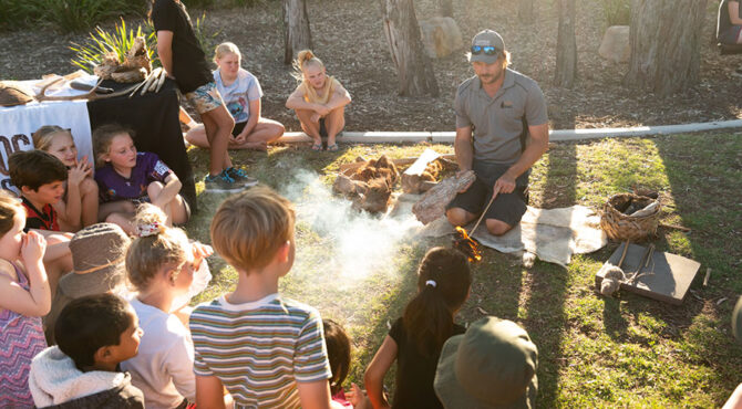 man demonstrating how to build a fire at community event in parkhurst