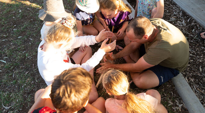 group of people all working together to make a fire at community event in rockhampton