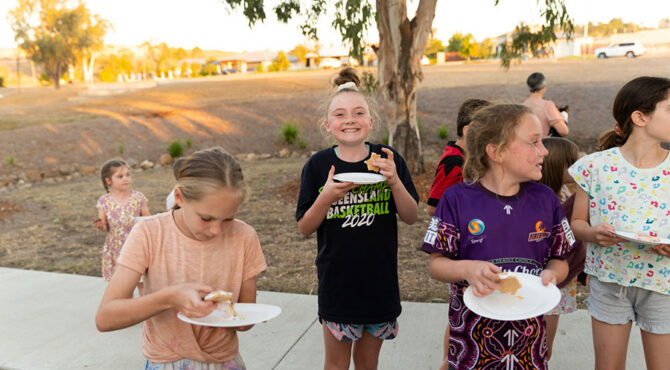 girl with big happy smile standing with other children at community event in rockhampton