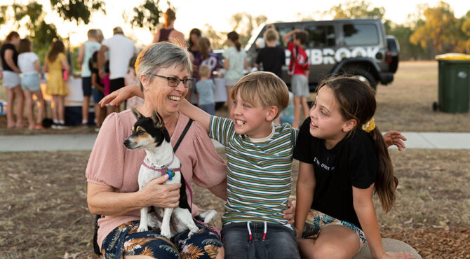 grandmother sitting with grand children and pet dog at edenbrook estate community event in rockhampton