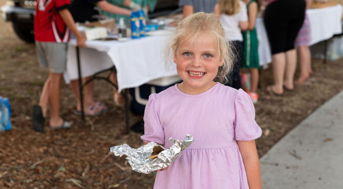 little girl holding toasted smore at rockhampton community event in edenbrook estate